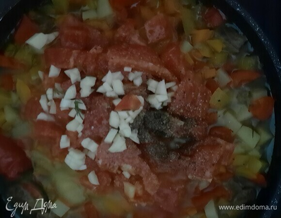 Затем добавляем помидор, чеснок и приправу для лагмана. Тушим еще 5–7 минут.