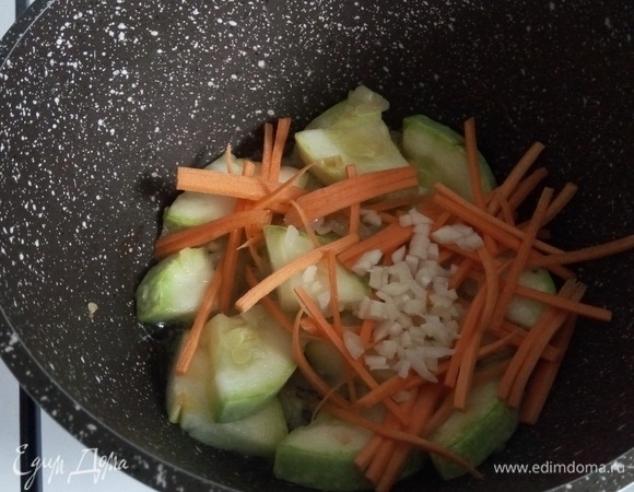 Нарезанную морковь и чеснок отправляем к кабачкам на 1 минуту, чтобы они пропитались.