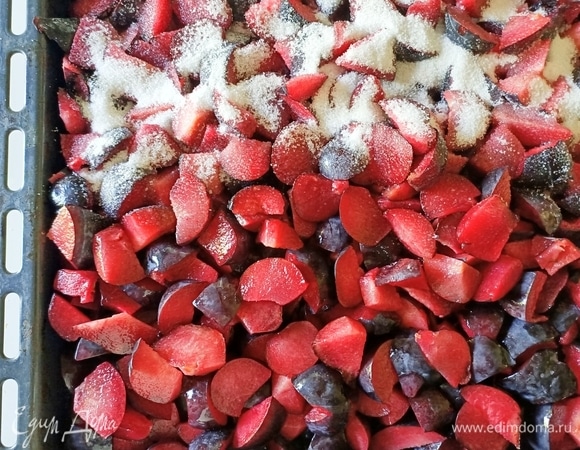 Нарезанные сливы выкладываем на противень, посыпаем сахаром и перемешиваем.
