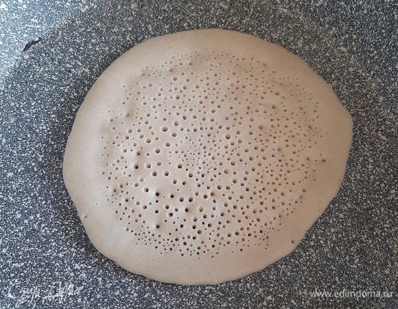 Влить тесто на смазанную маслом разогретую сковороду, после образования дырочек перевернуть блин.