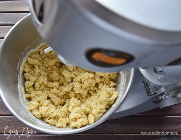 В чашу кухонной машины выложить муку, яичные желтки, соль, холодное сливочное масло и ледяную воду. Начать замешивать тесто, перетирая его в крошку.