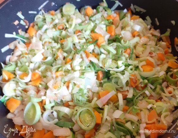 Когда лук и морковь немного прожарятся, добавляем и зелень лука-порея. Тщательно перемешиваем, чтобы все равномерно прожарилось. Солим и перчим.