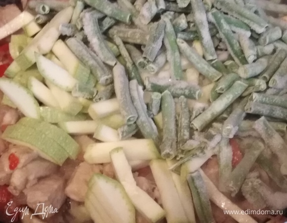 Всыпать нарезанный кабачок и замороженную фасоль. Жарить, помешивая, в течение 10 минут.