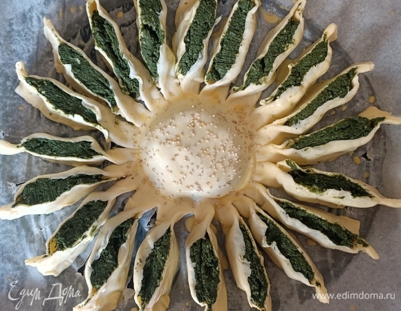 Убираем чашку. Смазываем пирог яйцом, предварительно смешав его с молоком. Центр посыпаем кунжутом или маком.