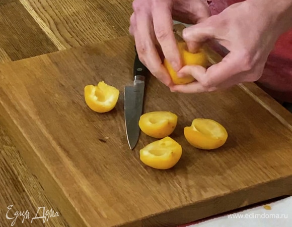 Абрикосы разрезать пополам и, удалив косточки, поместить часть из них внутрь цыпленка, остальные в форму рядом с ним.