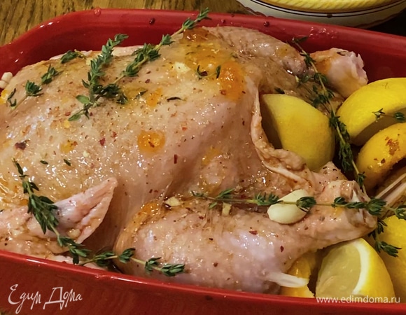 Полить тушку цыпленка соевым соусом и оставшимся оливковым маслом, добавить в форму зубчики чеснока и нарезанный лимон, посолить и поперчить, сверху разложить веточки тимьяна.