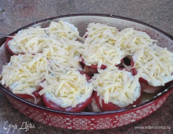 Для соуса смешайте майонез с измельченным чесноком, орехами и рубленой зеленью. У меня петрушка. Соус выложите на помидоры и посыпьте тертым сыром.