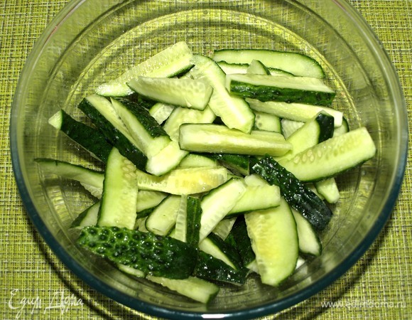 Огурцы промыть, удалить плодоножки и разрезать на две части поперек. Разрезать каждую часть вдоль и нарезать брусочками. Складываем подготовленные огурцы в миску, добавляем 1 ч. л. соли. Отставить, пока готовится говядина.