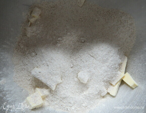 За 10 минут до приготовления воду и масло поместить в морозилку. Нам понадобится смесь из муки и маленьких кусочков сливочного масла. Муку просеять на рабочую поверхность, добавить мелко нарезанное масло, перетереть с мукой очень быстро, чтобы масло не успело растаять.