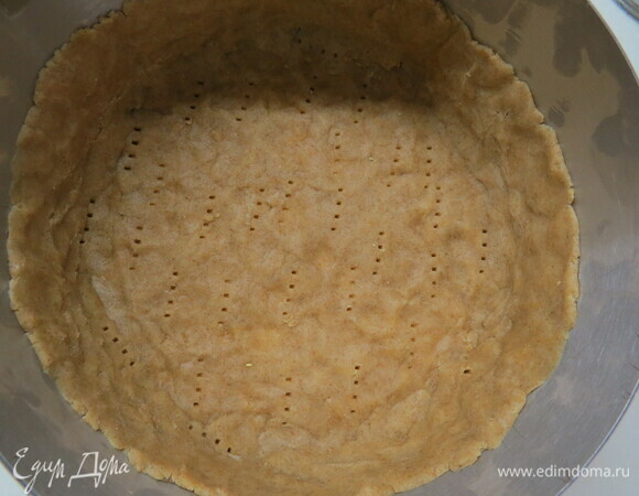 Дно формы застелить бумагой для выпечки. Раскатать тесто между двумя листами пергамента до толщины примерно 4 мм, выложить в форму, высота бортиков должна быть примерно 5–6 см, края теста обрезать, дно наколоть вилкой. Поставить форму с тестом в морозилку примерно на 10 минут.