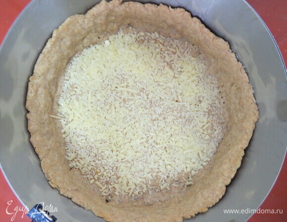 Выпекать примерно 20 минут при 200°C, достать из духовки, посыпать дно небольшим количеством твердого сыра и остудить.