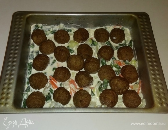 Затем туда же выкладываем фрикадельки, чуть утапливая их в овощах с соусом. Разогреваем духовку до 180°C и ставим в нее форму с овощами и фрикадельками на 30 минут (время приготовления зависит от вашей духовки). При подаче порционно украшаем зеленью петрушки. Приятного аппетита!