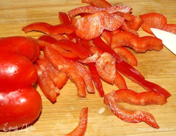 Красный сладкий перец очистить от плодоножки, перегородок и тонко нарезать.