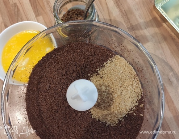 Покройте форму бумагой для выпечки как снизу, так и по бокам. Это хорошо работает, если заранее слегка смазать форму маслом, чтобы пергаментная бумага прилипала к ней. Разогрейте духовку до 180°C. Положите печенье в блендер и измельчите в мелкую крошку. Смешайте крошку печенья с растопленным маслом и разведенным в кипятке (50 мл) кофе.