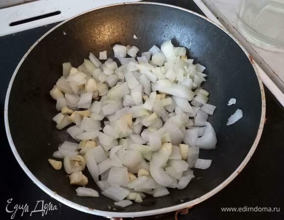 В маленькую сковороду налить подсолнечное масло, выложить измельченные лук и чеснок.