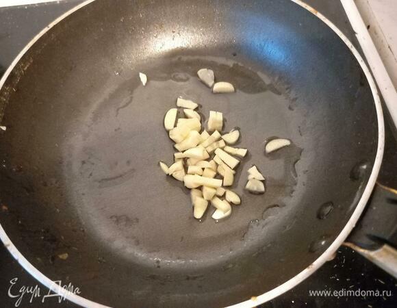 На маленькую сковороду влить подсолнечное масло, выложить чеснок. Включить сильный огонь.