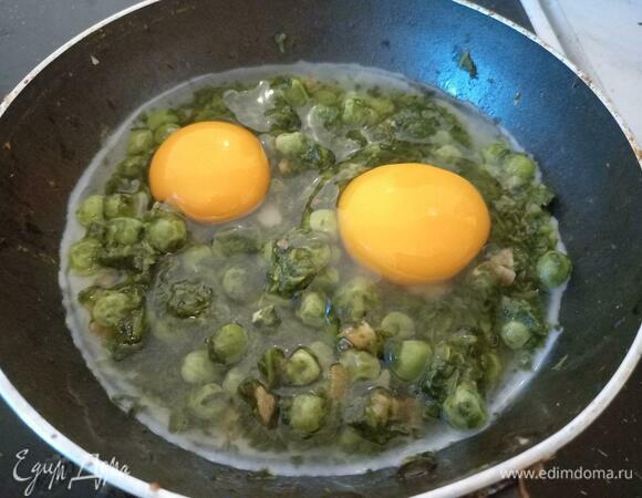 Сразу же аккуратно разбить два яйца поверх смеси, стараясь не повредить желток. Закрыть крышкой на две минуты, чтобы белок лучше схватился, но желток при этом оставался сырым.