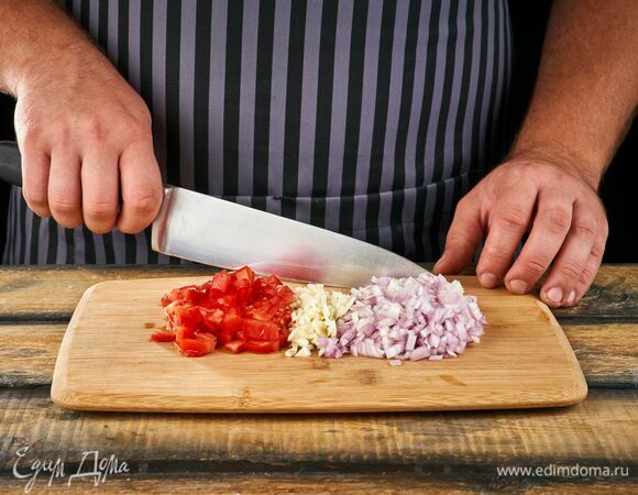 Лук и чеснок почистите и мелко порубите. Помидоры нарежьте мелким кубиком.