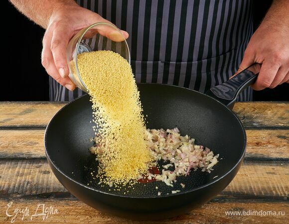 В сковороде на оливковом масле поджарьте до золотистого цвета лук и половину чеснока. Добавьте кускус.
