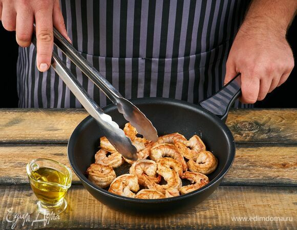 Пожарьте креветки на сковороде в оливковом масле около 2 минут.