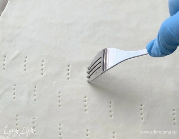 Переложите на противень, застеленный пергаментом, и проткните вилкой по всей площади.