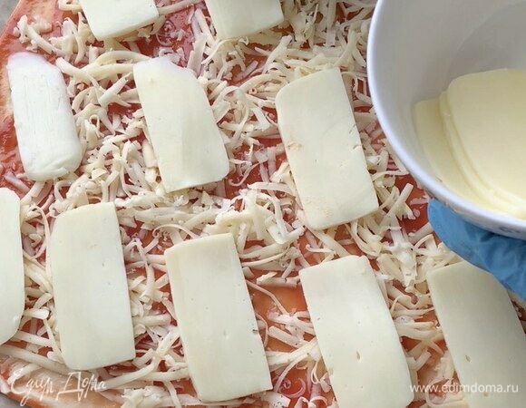 Затем выложите моцареллу, нарезав тонкими ломтиками.