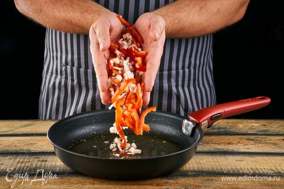 Добавьте в сковороду болгарский перец, нарезанный тонкими ломтиками, и лук, нарезанный кольцами. Жарьте в течение 3 минут.