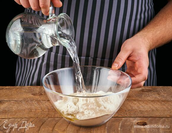 Сделайте углубление в муке и налейте в него воду.