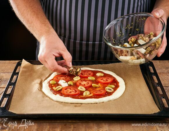 Выложите морской коктейль, помидоры и оливки.