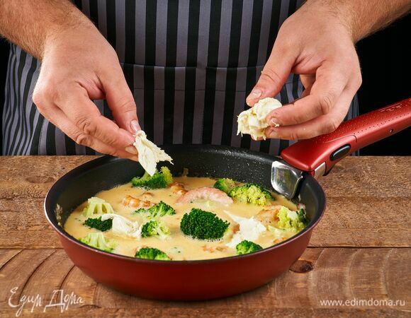 Порвите сыр и посыпьте сверху. Поставьте форму в заранее разогретую до 180°C духовку и выпекайте около 20 минут.