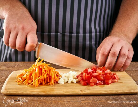 Морковь нарежьте соломкой. Чеснок мелко порубите. Помидор нарежьте мелкими кубиками.