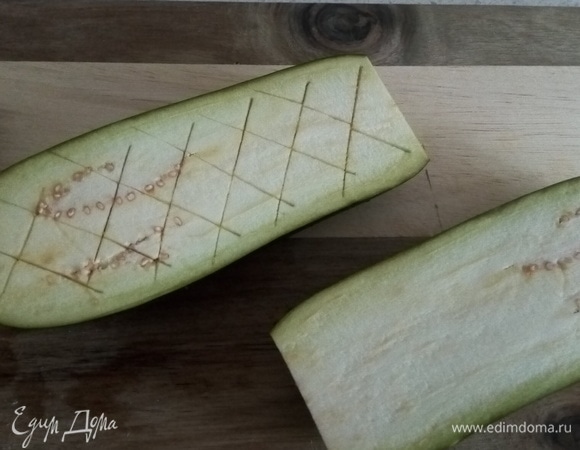 Разрезаем баклажаны пополам и нарезаем середину кубиками, не прорезая до конца. Солим, перчим.