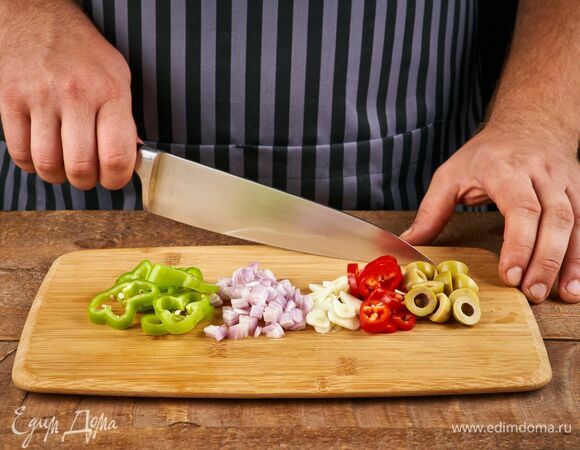 Чеснок нарежьте пластинками. Перец чили порубите. Шалот нарежьте мелким кубиком. Оливки — пополам.