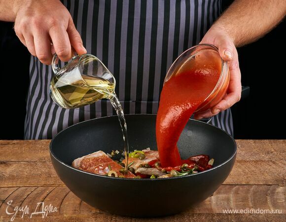 Влейте вино и перетертые томаты. Дайте алкоголю немного выпариться. Накройте сковороду крышкой и тушите около 5 минут до готовности рыбы.