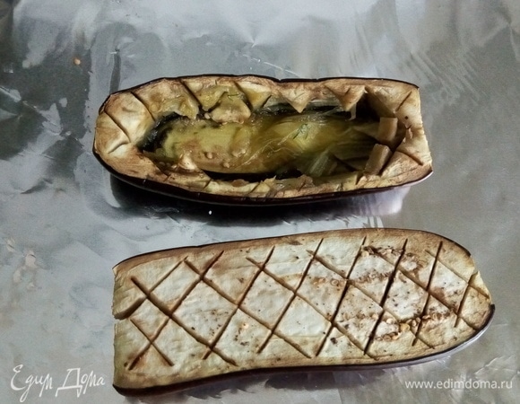 Пока мы готовили начинку, баклажаны обмякли. Мы легко сможем снять ложкой нарезанную квадратиками середину — получается лодочка.
