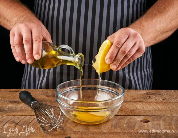 Сначала приготовьте домашний майонез. В чашке соедините яичные желтки, дижонскую горчицу, лимонный сок и половину оливкового масла. Перемешайте все с помощью венчика.