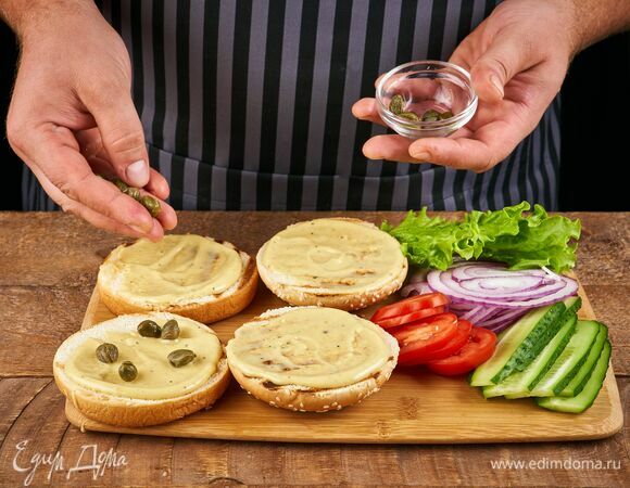 На одну половинку булочки выложите домашний майонез и каперсы.