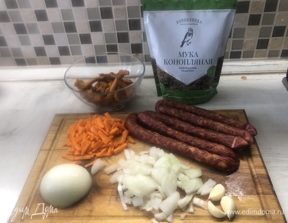 Нарежьте морковь (не трите), лук, колбаски. Отправляйте в масло на разогретую сковороду.