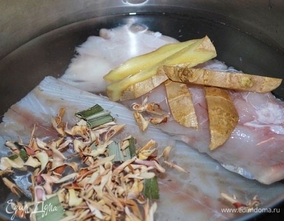 Рыбу положите в кастрюлю и полностью залейте водой (у меня примерно 1 л воды). Добавьте лемонграсс и половину корня имбиря (15 г). Доведите воду до кипения, добавьте 2 ст. л. рыбного соуса и варите все вместе 10 минут. После этого достаньте рыбу, а бульон процедите.
