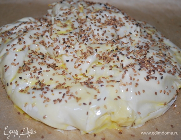 Сформировала пирог, смазала его яичным желтком и посыпала семенами кунжута. Выпекала при 170°C примерно 20–25 минут.