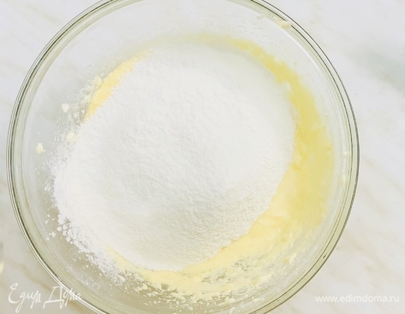 Смешиваем муку с содой и постепенно просеиваем в яичную массу. Перемешиваем миксером на маленькой скорости до однородности.