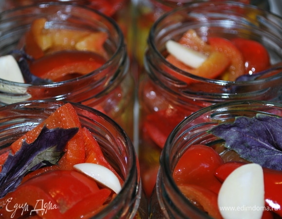 В стерилизованные банки добавить чеснок, веточку базилика, душистый перец, черный перец горошком и зонтик гвоздики по вкусу. Наполнить банки перцем, проваренным 2–3 минуты в маринаде.