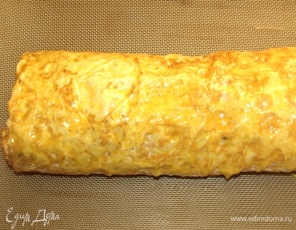 Желток взбить. Смазываем рулет желтком. Отправляем в заранее разогретую до 180ºC духовку на 20–30 минут.