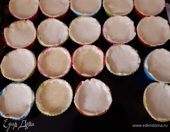 Разделите тесто на несколько частей. Каждую часть раскатайте достаточно тонко (2–3 мм). Вырежьте из теста кругляшки и поместите их в формочки для маффинов так, чтобы они закрывали стенки. Налейте внутрь начинку. Есть два варианта пирожных: можно их оставить как есть, а можно прилепить «крышечки» из теста сверху. Так как у меня начинки получилось меньше, чем теста, большинство пирожных я закрыла.