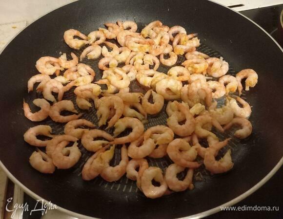 Выкладываем в сковороду креветки и обжариваем буквально минуту на сильном огне. Основная наша цель — пропитать масло креветочным запахом. Если используете сырые креветки, их нужно жарить немного дольше, пока они не станут розовыми.