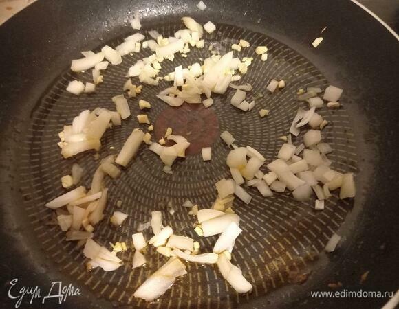 На той же сковороде, где жарились креветки, обжариваем лук и чеснок на сильном огне до появления золотистой корочки.