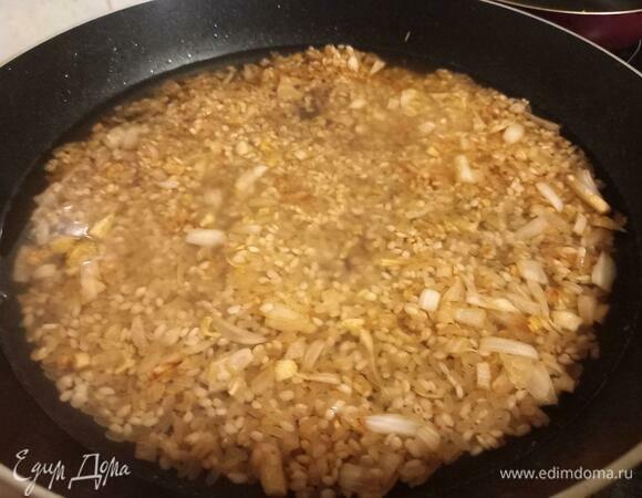 Равномерно выравниваем рис по поверхности сковороды и заливаем водой, чтобы она слегка покрывала рис. У меня было примерно 200 мл воды. Закрываем крышкой на 10 минут. После этого жарим рис еще 5–10 минут под крышкой, периодически помешивая.