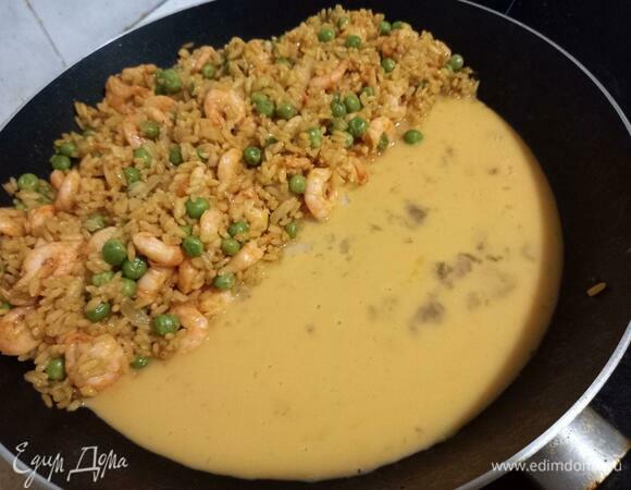 Сдвигаем весь наш рис с креветками и горошком на одну сторону сковороды, на другую выливаем яичную смесь.