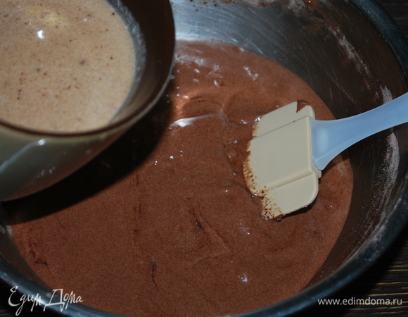 Сливки нагрела до 50–60°C, вылила их на шоколад и сливочное масло, размешала все до объединения и влила в тесто. Перемешала тесто лопаткой до однородного состояния.