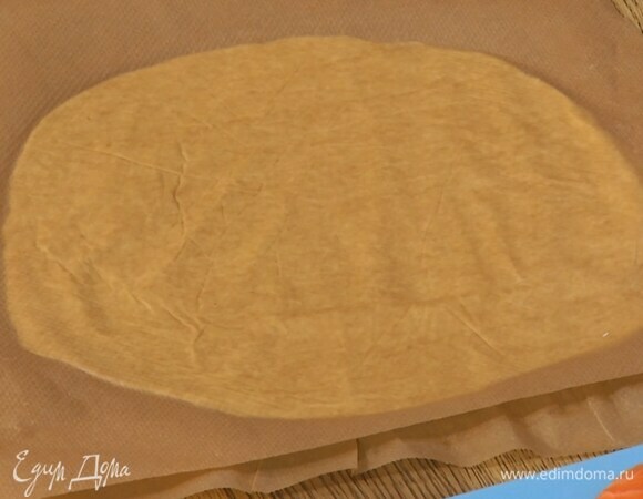 Охлажденное тесто разрезать пополам и раскатать между листами для выпечки в тонкие пласты.
